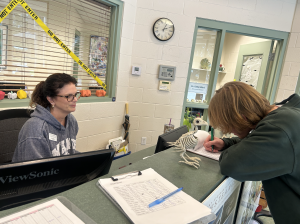 Senior Jack Horne signs in late.  This year, three tardies result in a 30-minute, after-school detention. 